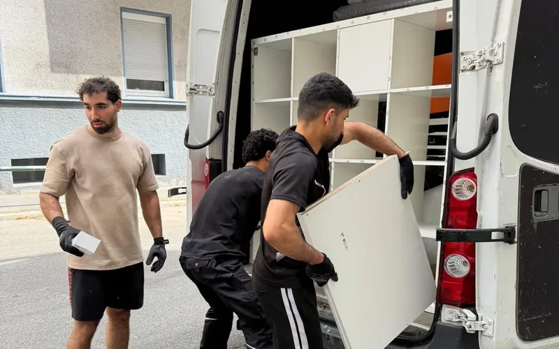 Privatumzug: Team von A & M Umzug lädt Möbel aus dem Umzugswagen