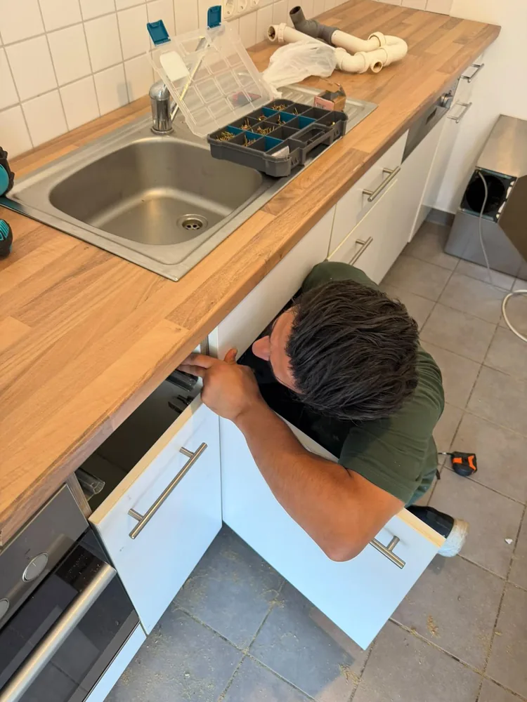 Mitarbeiter montiert eine Küchenzeile unter der Arbeitsplatte
