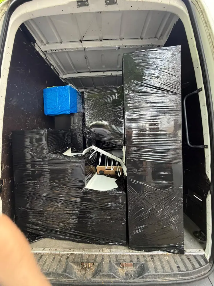 In Folie verpackte Möbel stehen gesichert im Transporter