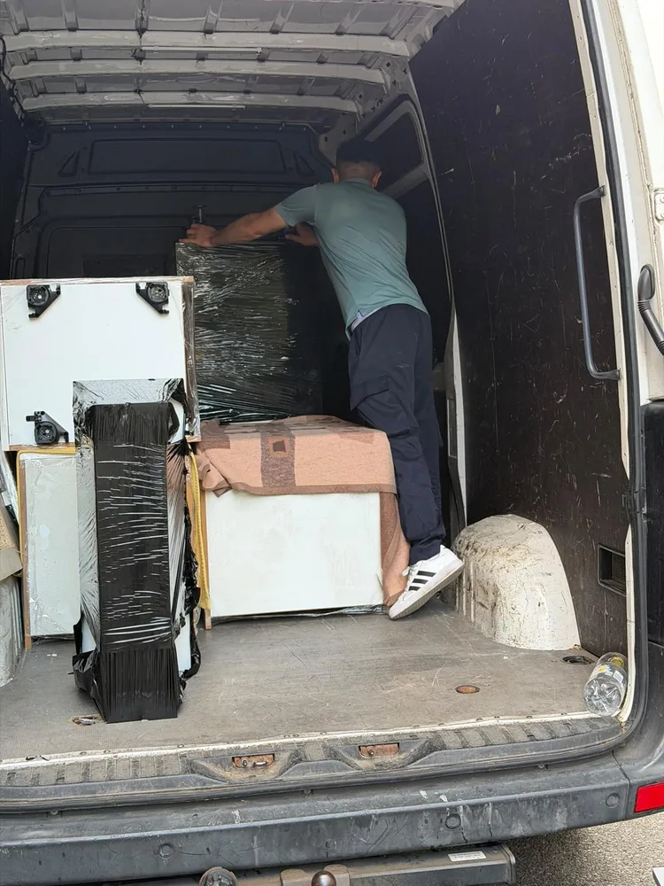 Mitarbeiter verlädt verpackte Möbel in den Transporter