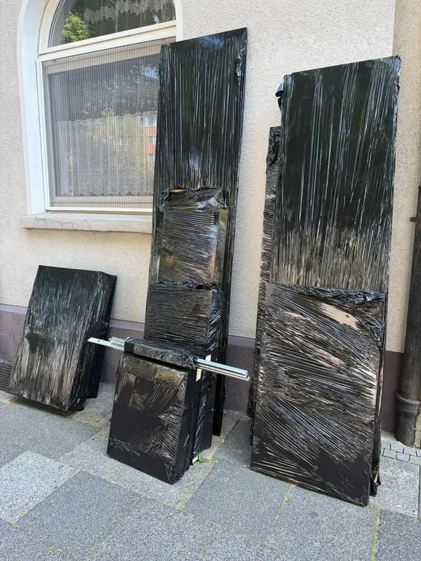Mit Folie geschützte Möbelteile an einer Hauswand